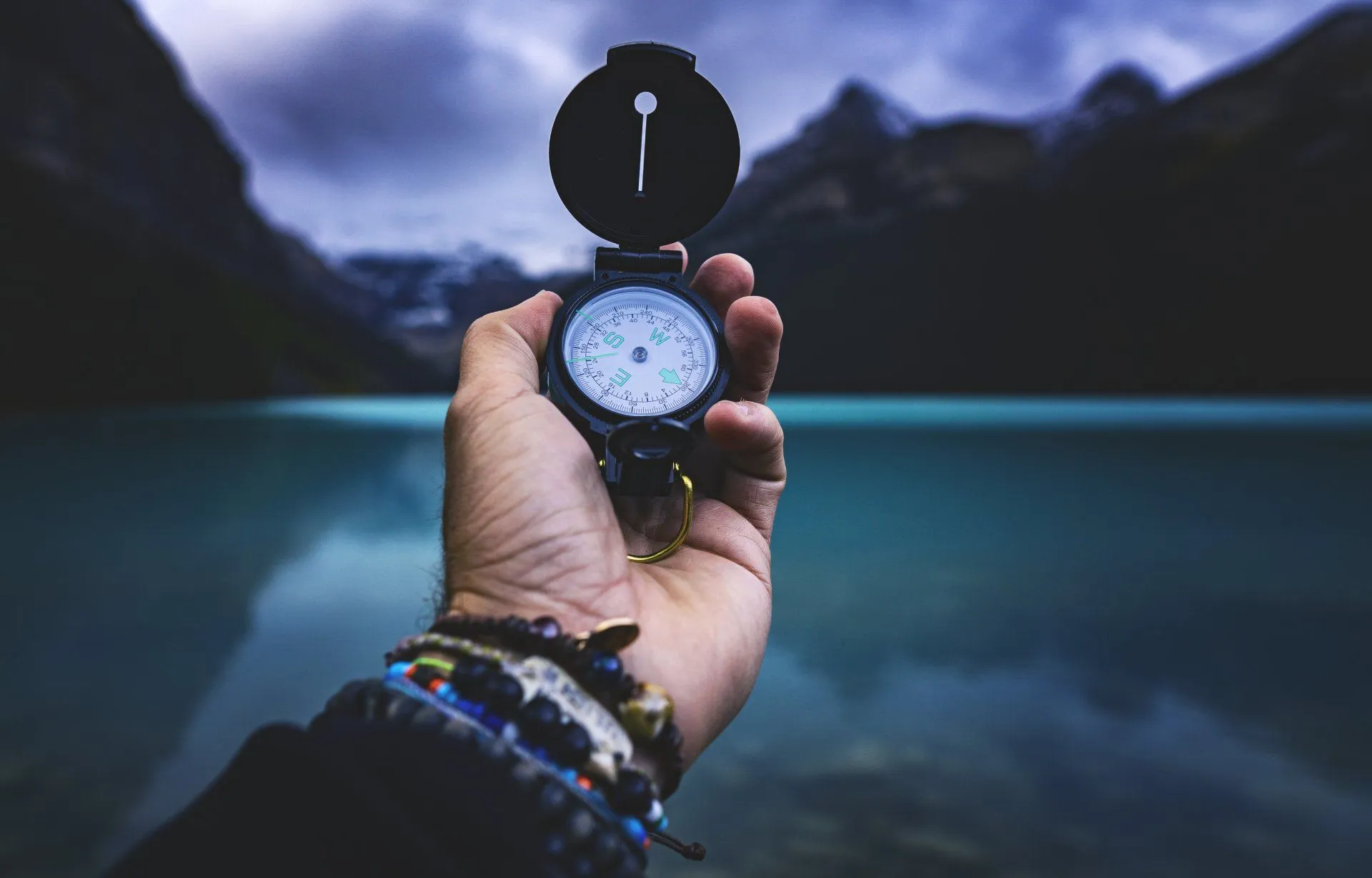 Compass held against a mountain landscape